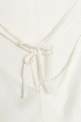 Vestido largo color rosa pálido, con escote en V pronunciado y tirantes finos tipo espagueti que se unen en la espalda. El corte es recto y holgado, con caída fluida.