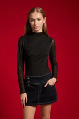 Body de manga larga confeccionado en poliéster con diseño al cuerpo, cuello alto y apliques de strass en tono negro con patrón de lunares brillantes y fruncidos diagonales en el frente.