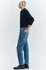 Pantalón jean de corte ajustado y tiro medio, en tono azul clásico con efecto deslavado.