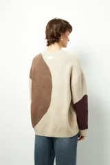 Sweater de punto con diseño geométrico en tres tonos de azul y gris, de cuello redondo y manga larga.