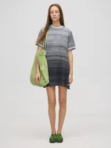 Vestido corto de punto con diseño degradado en tonos celestes y amarillos, cuello redondo y mangas cortas con detalles de rayas en los puños.