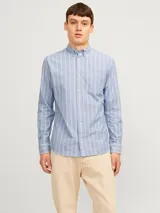 Camisa de vestir de manga larga con cuello abotonado y bolsillo frontal. Presenta un diseño de rayas verticales en tonos azul y blanco, con cierre frontal de botones.