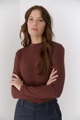 Polera blanca de viscosa con cuello alto y mangas largas.