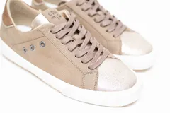 Championes de cuero legítimo color dorado con acabado metalizado, pasamontañas con cordones al tono y suela blanca con detalles de perforaciones laterales y talón contrastante.