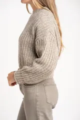 Sweater de punto grueso, color gris melange, con cuello redondo y manga larga, de calce oversize.