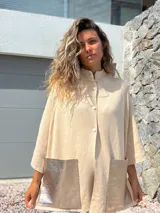 Saco tejido de punto en color crudo, con diseño holgado, mangas tres cuartos y bolsillos frontales grandes confeccionados en cuero metalizado plateado.