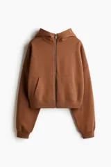 Campera con capucha de corte holgado y diseño cropped, confeccionada en felpa con interior cepillado. Presenta cierre frontal, hombros caídos, bolsillos tipo parche y terminaciones en punto acanalado en puños y bajo.