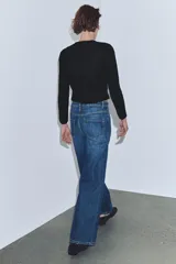 Jeans de tiro alto, color beige claro, con pierna ancha y cinco bolsillos.