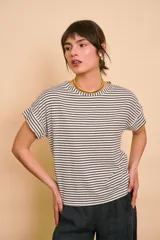 Remera de corte holgado, con diseño a rayas horizontales en color crudo y azul marino, cuello redondo y mangas cortas con vuelta.