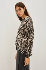 Sweater de punto con diseño de estampado animal print de cebra, cuello redondo y mangas largas con corte holgado.