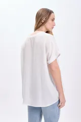 Camiseta blanca de manga corta con dobladillo en las mangas y cuello redondo.