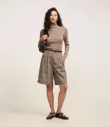 Suéter de punto color borgoña, con cuello alto estructurado y mangas largas.