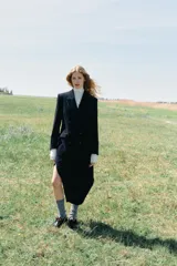 Blazer de pana azul marino con diseño cruzado, cuello solapa, hombreras marcadas y cierre frontal con botones. Cuenta con bolsillos delanteros con solapa y abertura en la espalda.