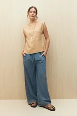 Top sin mangas de lino y viscosa, color negro, con escote redondo y caída relajada. Presenta hombros levemente marcados y botones forrados en la espalda.