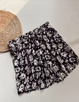 Short negro con estampado floral blanco, con cintura elastizada y lazo para ajustar.