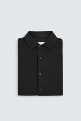 Camisa de manga larga color celeste claro, corte slim fit, con cuello italiano abierto y cierre frontal de botonadura.