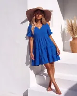Vestido corto color azul de lino, con escote en V, mangas cortas con volados y diseño escalonado en la falda.