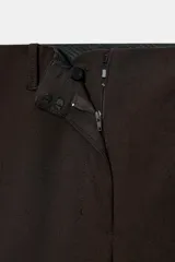 Bermuda larga color marrón oscuro, de tiro medio con cintura con trabillas. Presenta bolsillos laterales ocultos en la costura y detalle de raya planchada. Cierre frontal con cremallera, botón y ganchos metálicos.