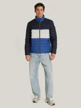 Chaqueta acolchada de diseño color block en tonos azul marino, blanco y azul brillante. Presenta cuello alto, cierre frontal con cremallera y bolsillos laterales con cierre. Incluye el logo de la marca bordado en el pecho y detalle distintivo en la manga.
