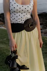 Faja ancha de cuero sintético negro con hebilla dorada y bolsillo lateral.