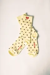 Medias largas color marrón con estampado de lunares celestes. Tienen un corazón rojo bordado con la letra 'R' en blanco en la parte superior y la palabra 'Rotunda' en rojo en el lateral del pie.