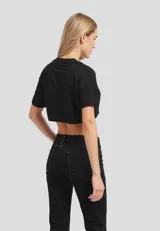 Remera cropped de algodón, color gris claro, con cuello redondo y manga corta doblada. Presenta un estampado frontal de un plátano amarillo.