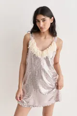 Vestido corto de lentejuelas brillantes con escote en V decorado con flecos de tela. Presenta un corte recto y tirantes anchos.