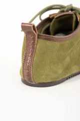 Zapatilla baja color verde oliva de gamuza con cordones y suela de goma.