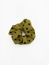 Colita de pelo tipo scrunchie de tela texturizada color verde oliva con estampado de lunares negros.