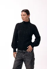 Polera de cuello alto con diseño de trenzas verticales en tejido de punto suave, de manga larga con puños ajustados.