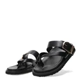 Sandalias planas Miss Carol modelo Solara de color negro, con diseño de tiras cruzadas y hebilla metálica decorativa dorada en el empeine.