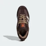 Championes Adidas modelo Samba XLG, de diseño urbano con suela de plataforma. Presentan una combinación de tonos marrones en gamuza y cuero, con las icónicas tres franjas laterales en color beige y detalles en naranja vibrante en la lengüeta y el lateral.