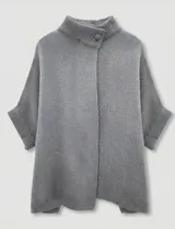 Capa tejida color fucsia, con cuello alto abotonado y mangas cortas estilo japonesa. Tejido de punto grueso.