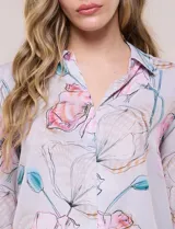 Blusa de gasa liviana con estampado animal print que combina leopardo y cebra, cuello camisero con escote en V y mangas largas con puños anchos.