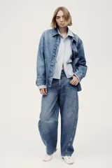 Campera camisera en denim rígido con cuello, cierre frontal de botones, puños abotonados, bolsillos de parche delanteros y dobladillo redondeado.