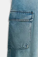 Pantalón tipo cargo de tiro medio confeccionado en denim azul. Presenta bolsillos laterales con solapa, bolsillos delanteros y traseros, y un cinturón integrado del mismo tejido con hebilla metálica.