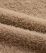 Suéter color beige de punto con textura de pelitos, cuello alto y mangas largas.