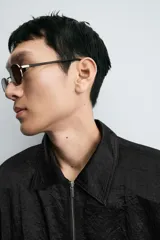 Cazadora bomber negra con textura arrugada, cuello solapa, hombreras marcadas, manga larga con puño abotonado, bolsillos de vivo en la cadera, bajo elástico y cierre frontal con cremallera.