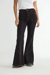 Jean de corte flare en color negro, con costuras verticales decorativas en contraste y ruedo deshilachado.