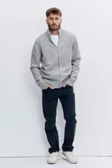 Cardigan de punto color gris con cierre frontal completo, cuello alto y puños acanalados. Presenta un pequeño logo bordado en el pecho.