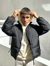 Campera puffer negra de nylon con cierre frontal y cuello alto.