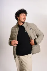 Campera puffer color beige con cierre frontal, cuello alto y logo de la marca bordado en el pecho.
