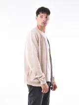 Campera tejida de punto con cierre frontal, cuello redondo y puños acanalados. Presenta una textura sutil en el tejido y un diseño versátil.