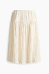 Pollera evasé midi de punto texturizado en color blanco, con elástico revestido en la cintura y costura fruncida con ribete bajo la cadera.