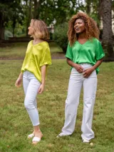 Blusa de satén color verde, con escote en V y mangas cortas con dobladillo.