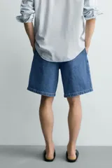 Bermuda de denim de algodón con corte relaxed fit, cintura con pliegues dobles en el delantero, bolsillos laterales y traseros de doble vivo, con efecto lavado y cierre frontal con cremallera y botón.