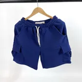 Bermuda azul marino de algodón fino con textura waffle, corte recto, cintura elástica con cordón ajustable, bolsillos laterales y bolsillos cargo con solapa en los laterales.