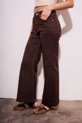 Pantalón de jean marrón con estampado animal print, corte flare y tiro medio.