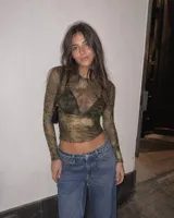 Top de microtul verde con estampado abstracto, manga larga y cuello redondo. Presenta terminaciones con dobladillo ondulado en el cuello, los puños y el ruedo.