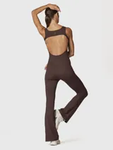 Enterito largo color chocolate, de tirantes, confeccionado en tejido suave y elástico. Presenta espalda abierta y piernas ligeramente anchas.